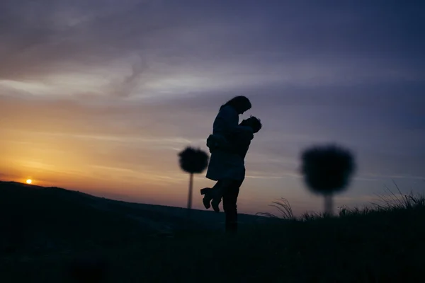 Silhueta de um casal amoroso beijando no por do sol — Fotografia de Stock