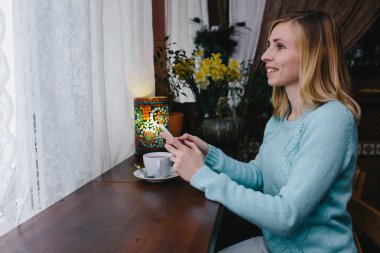 Güzel gülümseme ile büyüleyici kadın mobil iyi haber okuma 