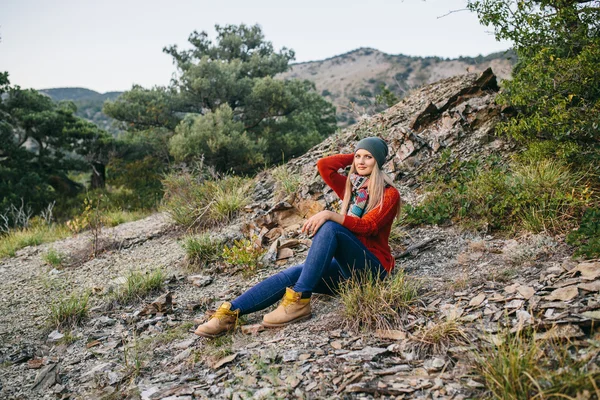 Portrait d'une belle jeune femme blonde assise en plein air sur le fond de montagne et de forêt — Photo
