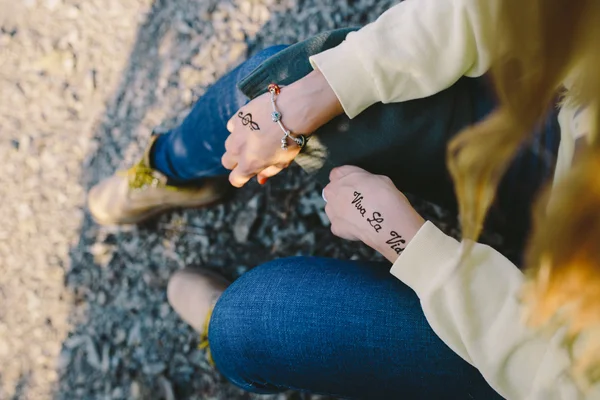 Imagem cortada de uma mão de uma jovem mulher com as inscrições Mehndi "Viva la Vida" e sinal de fenda agudo. conceito — Fotografia de Stock