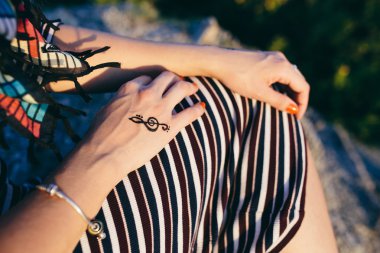 Mehndi görüntü tiz clef işareti ile çizgili bir elbise ve renkli eşarp genç bir kadının elleri kırpılmış görüntü. Kavram