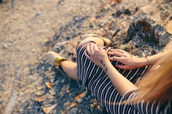 Imagen recortada de una mano de una joven con un vestido a rayas y botas amarillas con las inscripciones Mehndi "Viva la Vida" y signo de clave triple. concepto — Foto de Stock