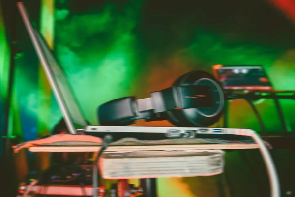 Přenosný počítač DJ sluchátka v nočním klubu, rozostřeného obrazu — Stock fotografie