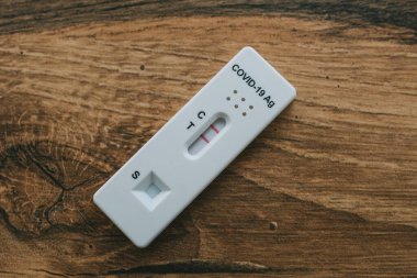 Pozitif COVID-19 (SARS-CoV-2) Antijen Hızlı Testi, ahşap zemin üzerinde izole