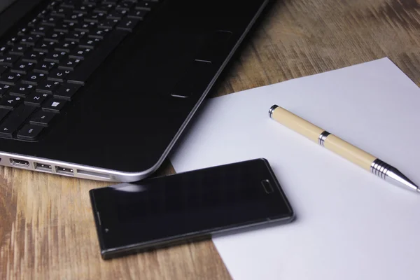 Бізнес смартфон на клавіатурі, з ручкою — стокове фото