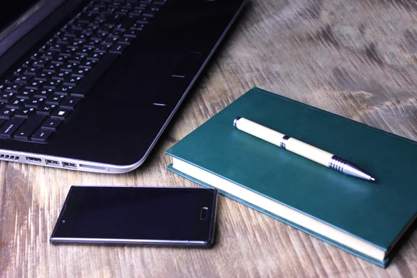 Bir dizüstü bilgisayar, bir kitap ve bir akıllı telefon ile yeşil bir genel gider atış