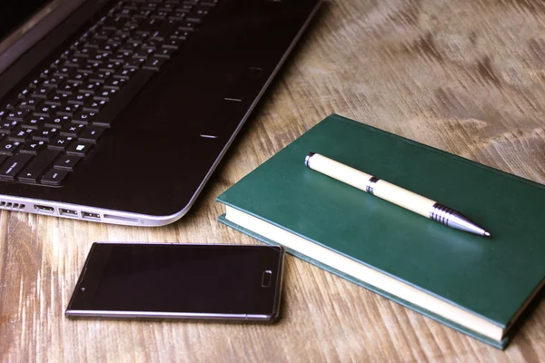 一台笔记本电脑、 一本书和智能电话，与绿色的开销出手 — 图库照片