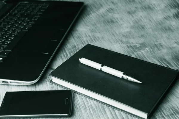 Bir dizüstü bilgisayar, bir kitap ve bir akıllı telefon ile yeşil bir genel gider atış