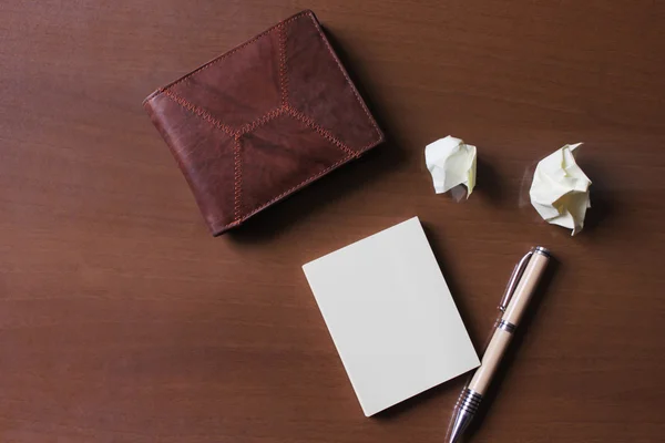 Caneta notebook e carteira na mesa de madeira com tom de desbotamento, espaço para — Fotografia de Stock