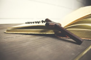 Haç ve kitap ahşap bir masada.