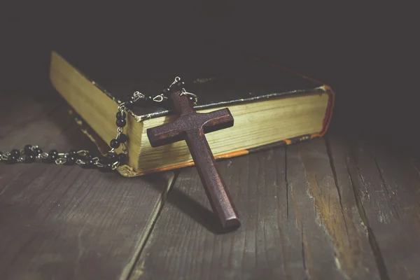 Krzyż i książka na drewnianym stole — Zdjęcie stockowe
