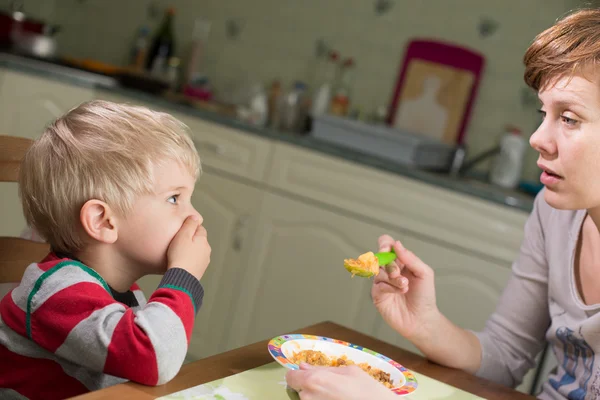 Blonder Junge hält Hand auf seinen Mund, um aufzuhören zu essen — Stockfoto