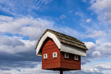 RICHMOND, CANADA - Nisan 04, 2020: Beyaz bulutlu mavi gökyüzüne karşı baykuş evi modeli.
