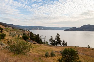 PEACHLAND, CANADA - 01 Ağustos 2020 Okanagan göl manzarası yaz saatinde sabah mavi gökyüzü.