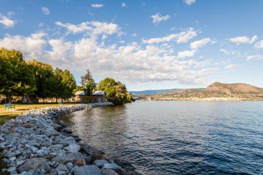 NARAMATA, CANADA - 5 HAZİRAN 2020: Güzellik güneşli göl manzaralı gökyüzünde beyaz bulutlar