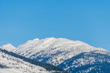 Üstünde kar olan yüksek dağlar açık mavi gökyüzü Britanya Kolumbiyası Kanada.