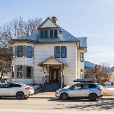 REVELSTOKE, CANADA - 16 Mart 2021: Tarihi binalar ve modern arabalarla küçük bir kasabada sokak manzarası