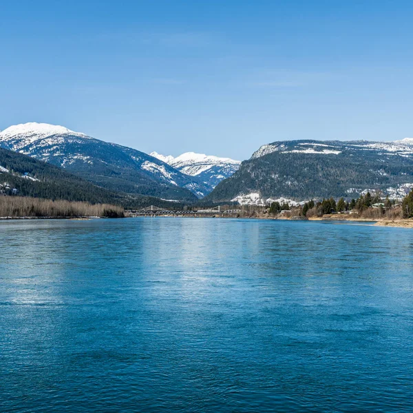 Inizio primavera Columbia fiume con neve sulle montagne cielo blu British Columbia Canada — Foto Stock