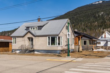 REVELSTOKE, CANADA - 16 Mart 2021: Tarihi binalar ve modern arabalarla küçük bir kasabada sokak manzarası.