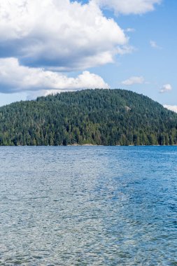 Kuzey Vancouver 'dan Hint Kolu' na bakın. Kanada güneşli bir bahar günü. Mavi gökyüzünde beyaz bulutlar..