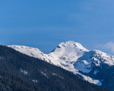 Güzel kar kaplı Columbia Dağları Britanya Kolumbiyası Kanada 'da mavi gökyüzüne karşı.