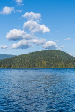Kuzey Vancouver 'dan Hint Kolu' na bakın. Kanada güneşli bir bahar günü. Mavi gökyüzünde beyaz bulutlar..