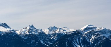 Güzel kar kaplı Columbia Dağları Britanya Kolumbiyası Kanada 'da mavi gökyüzüne karşı.