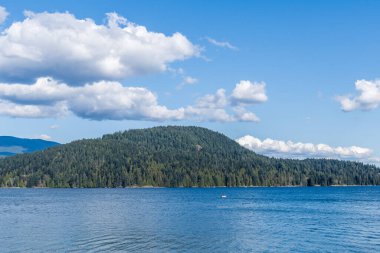 Kuzey Vancouver 'dan Hint Kolu' na bakın. Kanada güneşli bir bahar günü. Mavi gökyüzünde beyaz bulutlar..
