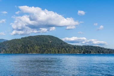 Kuzey Vancouver 'dan Hint Kolu' na bakın. Kanada güneşli bir bahar günü. Mavi gökyüzünde beyaz bulutlar..