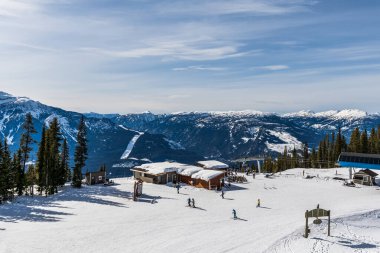 REVELSTOKE, CANADA - 17 Mart 2021: Kayak pisti kablo kaldırma istasyonundaki insanlar.