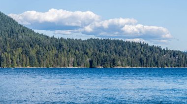 Kuzey Vancouver 'dan Hint Kolu' na bakın. Kanada güneşli bir bahar günü. Mavi gökyüzünde beyaz bulutlar..