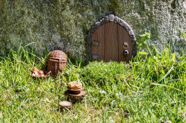 Taş duvar fantezi dünyasında çamurdan yapılmış elf evi kapısı..