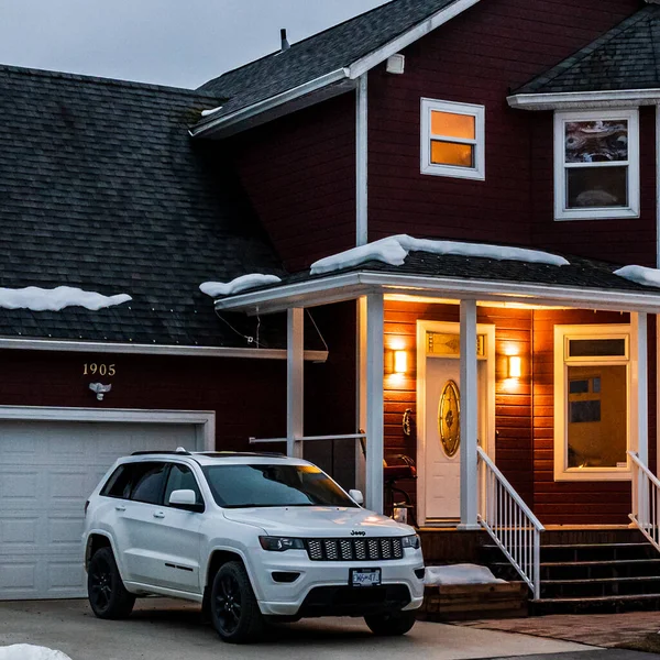REVELSTOKE, CANADA - 14 Mart 2021: akşam erken saatlerde küçük bir kasabada arabası olan özel bir ev.
