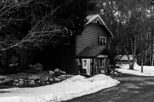 रिव्हलस्टोक, कॅनडा मार्च 14, 2021: लहान शहरातील संध्याकाळी लवकर वसंत ऋतू बर्फ सह काळा आणि पांढरा खाजगी घर — स्टॉक फोटो, इमेज