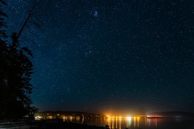 Gece görüşü Waddington Dağı 'ndaki küçük bir kasabaya. Karanlık gökyüzünde bir sürü yıldız..