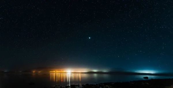 Gece görüşü Waddington Dağı 'ndaki küçük bir kasabaya. Karanlık gökyüzünde bir sürü yıldız..