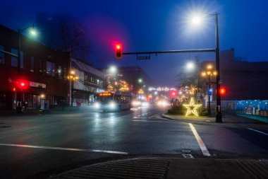NEW WESMINSTER, CANADA - 24 ARALIK 2020: Aydınlatma sisli sabahıyla gece şehir caddesi.