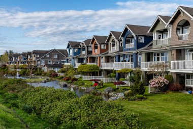 RICHMOND, CANADA - 19 Nisan 2025: Modern sürdürülebilir konut binaları, yeşil şehir manzaralı bir yerleşim alanı