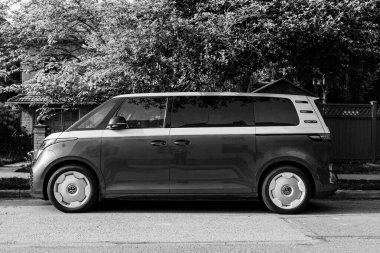 VANCOUVER, CANADA - MAYIS 09, 2025: - siyah beyaz elektrikli minivan, kuzeye giden iskan yolunun üzerinde park halinde.