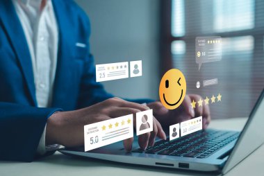 Müşteri geribildirimi ve çevrimiçi değerlendirme konsepti, dijital pazarlama, hizmet değerlendirmesi ve iş itibarının iyileştirilmesi için dizüstü bilgisayar ekranında yıldız reytingleri, yorumlar ve gülümseme simgeleri göstermektedir..