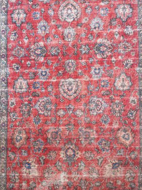 Eski İran halısı, soluk kırmızı arka plan ve mavi ve bej renklerle karışık çiçek motifleri. Antik oryantal halı dokusu, geleneksel el yapımı tekstil tasarım ve dekorasyon için yıpranmış görünüme sahip..