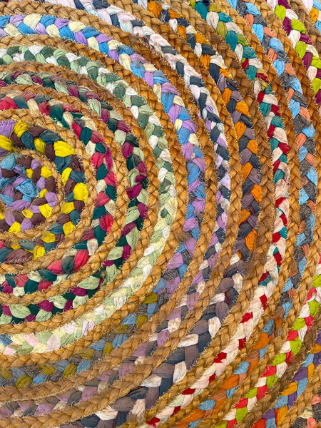 Цветной плетеный ковер из тканых полос и натуральных волокон, выстроенных в концентрические круги. Чешский текстильный фон ручной работы, экологически чистый декор и традиционный ремесленный узор для концепций дизайна интерьера.