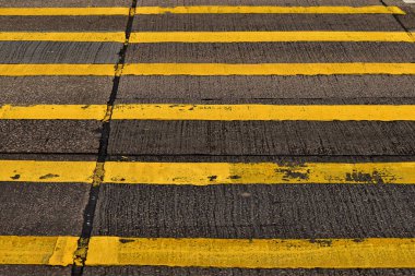 Asfalt yol yüzeyi dokusu ve yol merdiveni işaretinde sarı boya çizgilerine yakın plan. Yaya geçidi. Ulaşım konsepti. Arkaplan kullanımı için.