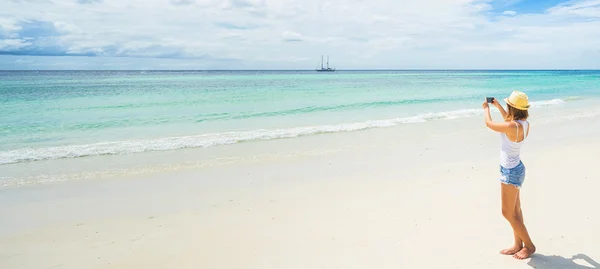 Toerist met camera op het strand — Stockfoto