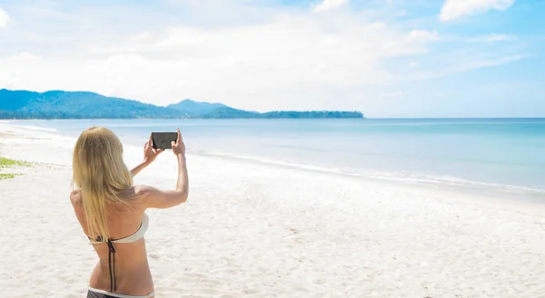 Turista tomando fotos de la playa — Foto de Stock