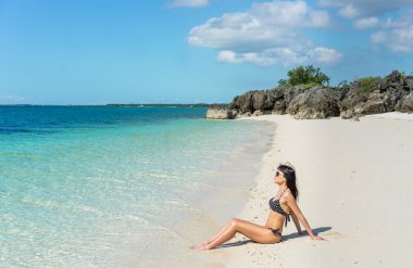 Kumsalda genç bir kadın.  