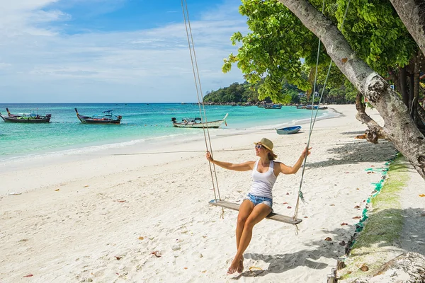 Vrouw swingen op een tropisch strand — Stockfoto