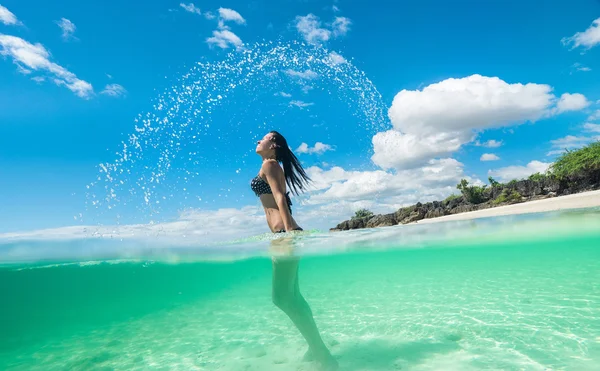 Kvinna stänkande vatten med hennes hår — Stockfoto