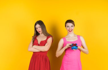 Kız bir hediye aldı ve diğer kız ile kızgın görünüyor. 