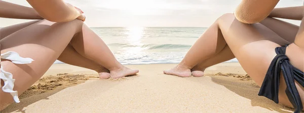 Two young women sitting on the beach. — Stock Photo, Image